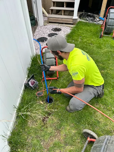 Technician using sewer camera equipment to inspect an underground drain line